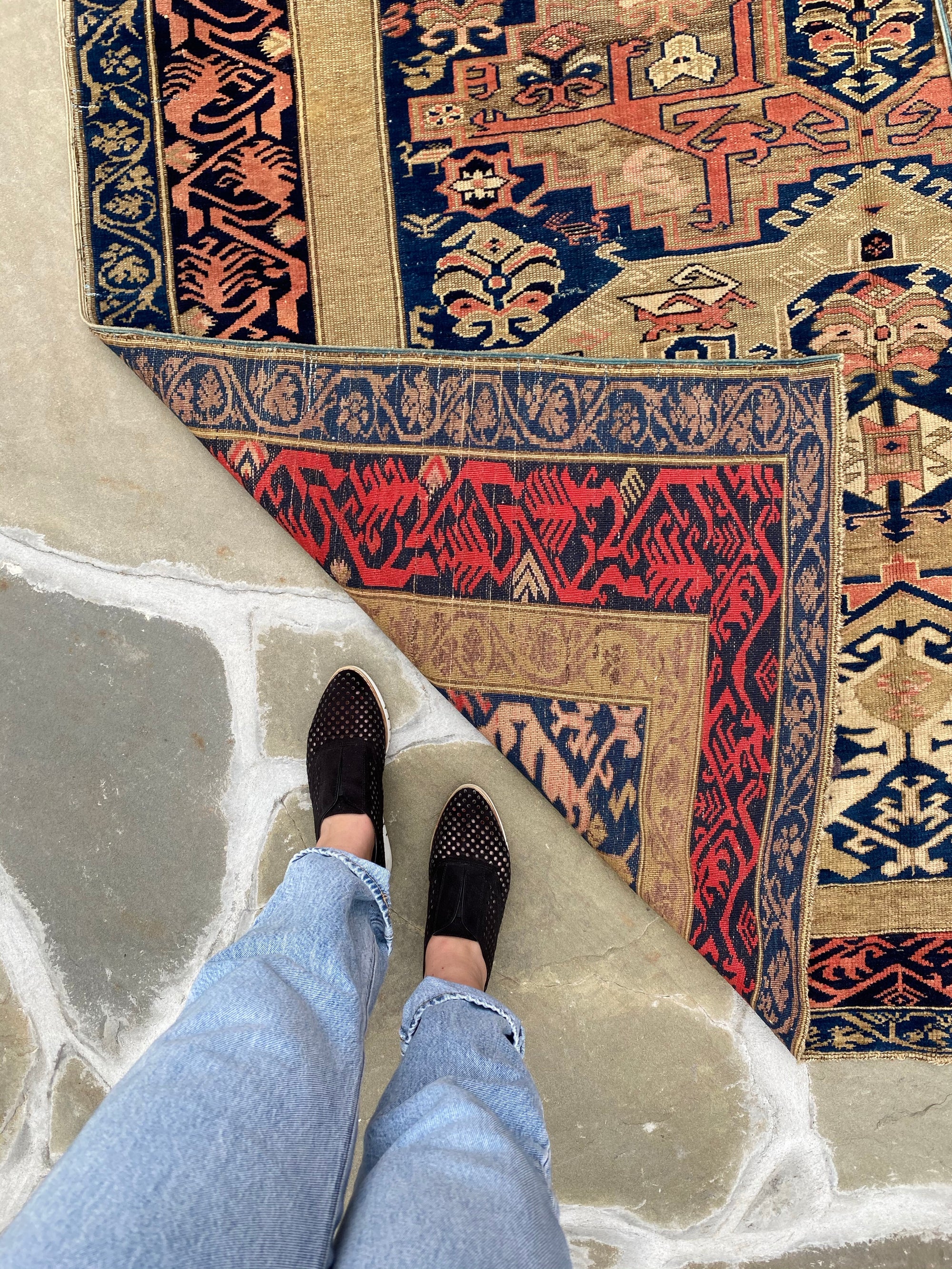 standing next to Antique Caucasian Zekhur Kuba rug